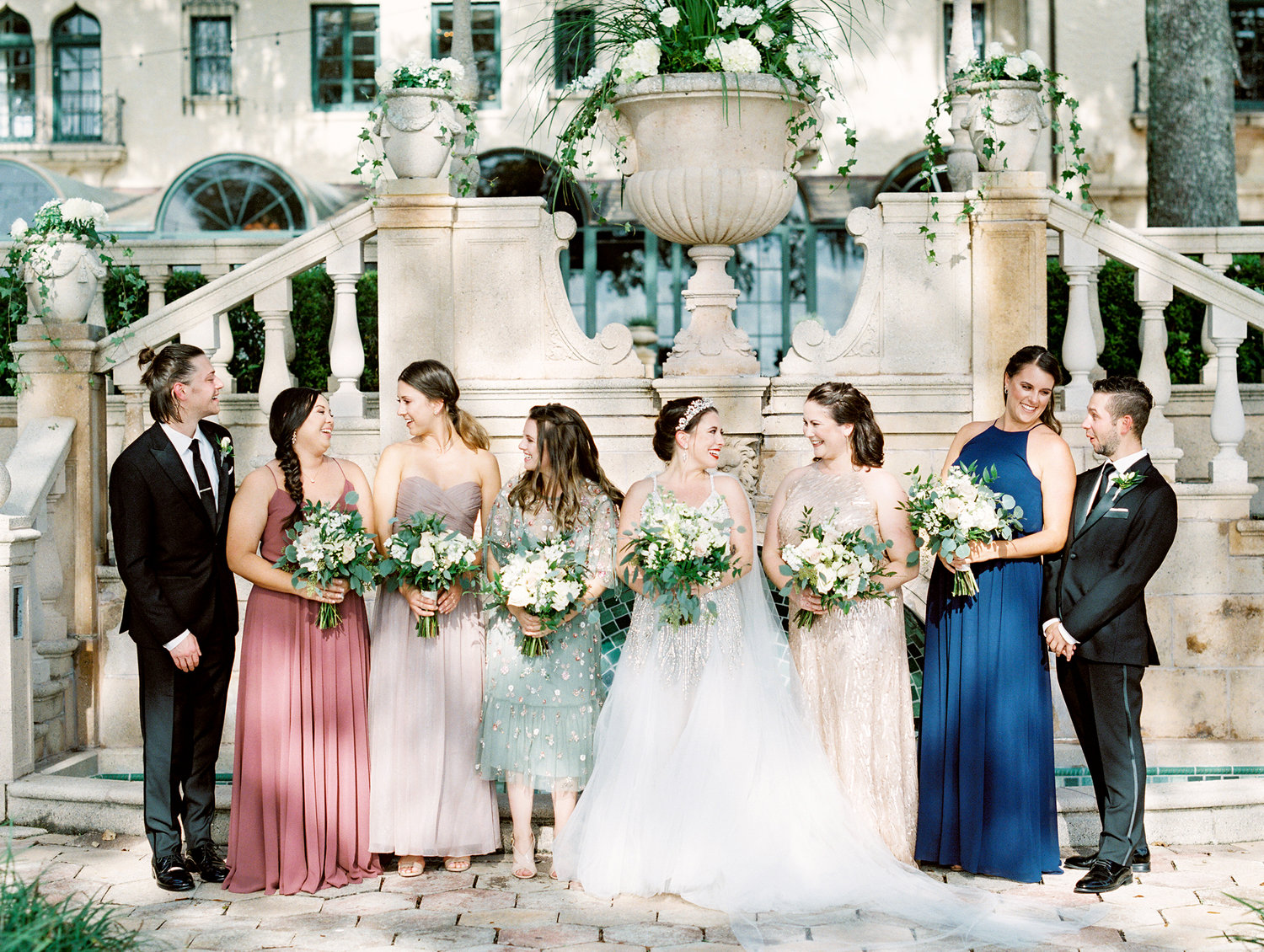 Bride and wedding party gathered outside an elegant venue